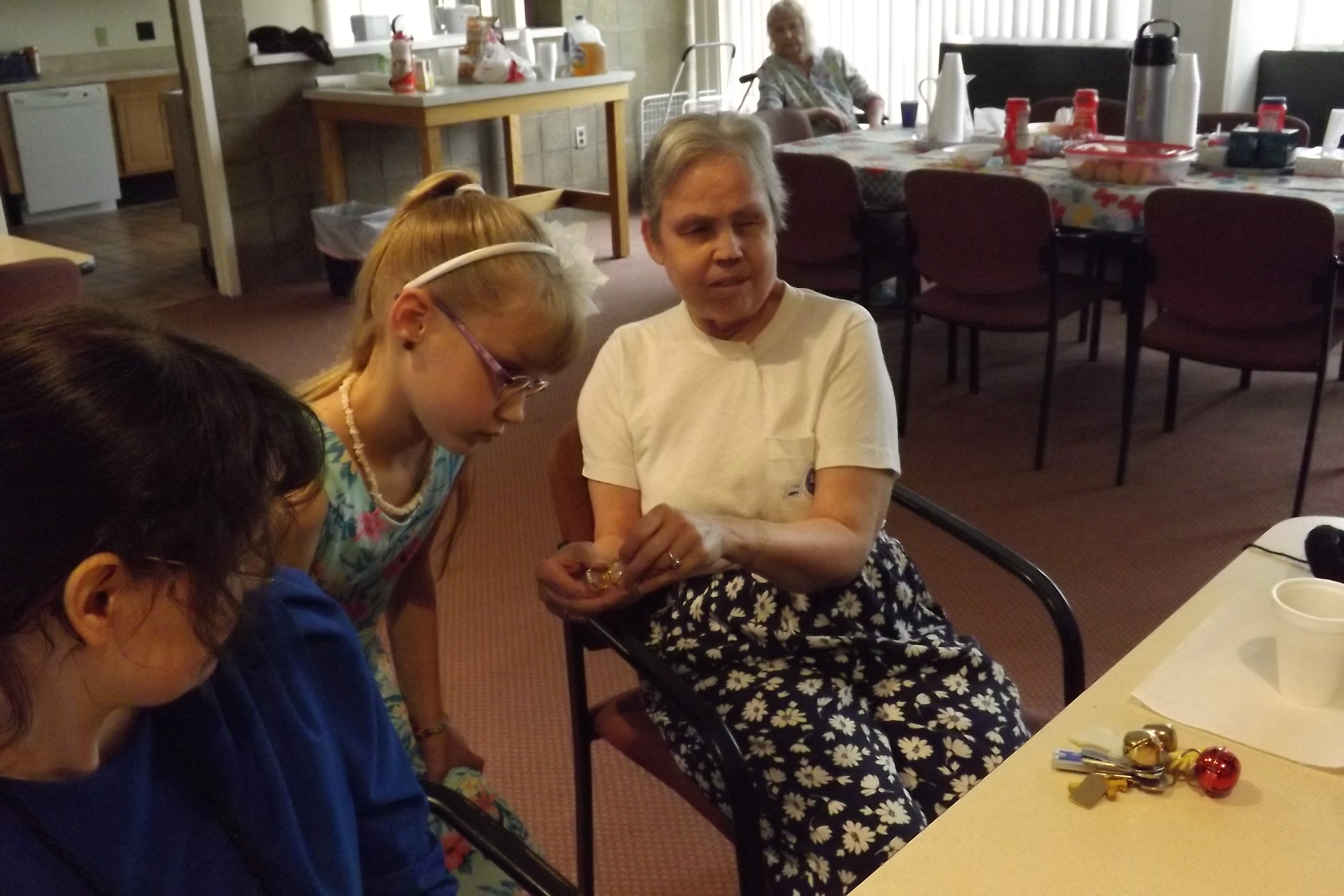 Kay shows her braille watch to Savannah at an Adaptive Life Skills Meeting.
